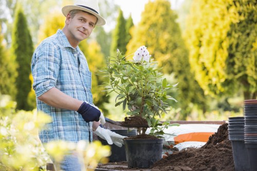 Operative wearing PPE performing a lawn mowing task